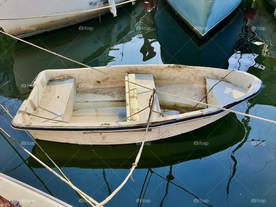 Another view of the dinghy in the waters of the East River at Newtown Creek in LIC, Queens, NY photographed on a summertime afternoon in 2021. Hypnotic Productions