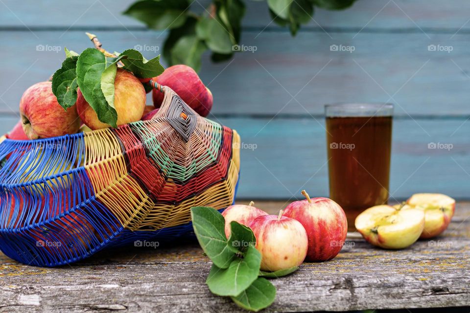 Summer garden apples in a wicker basket and apple juice