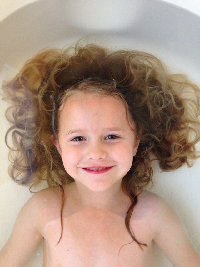 Cute girl bathing in tub