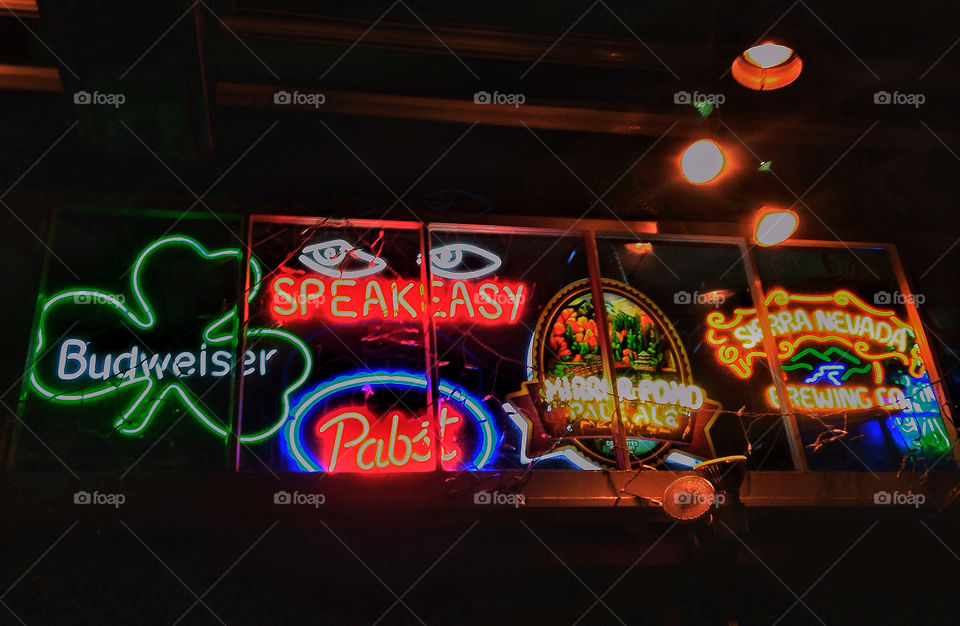 Bright neon beer logo signs in window of San Francisco, college,