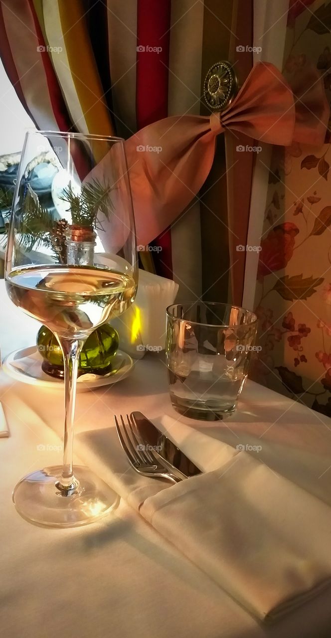 A glass of wine on a table in a restaurant