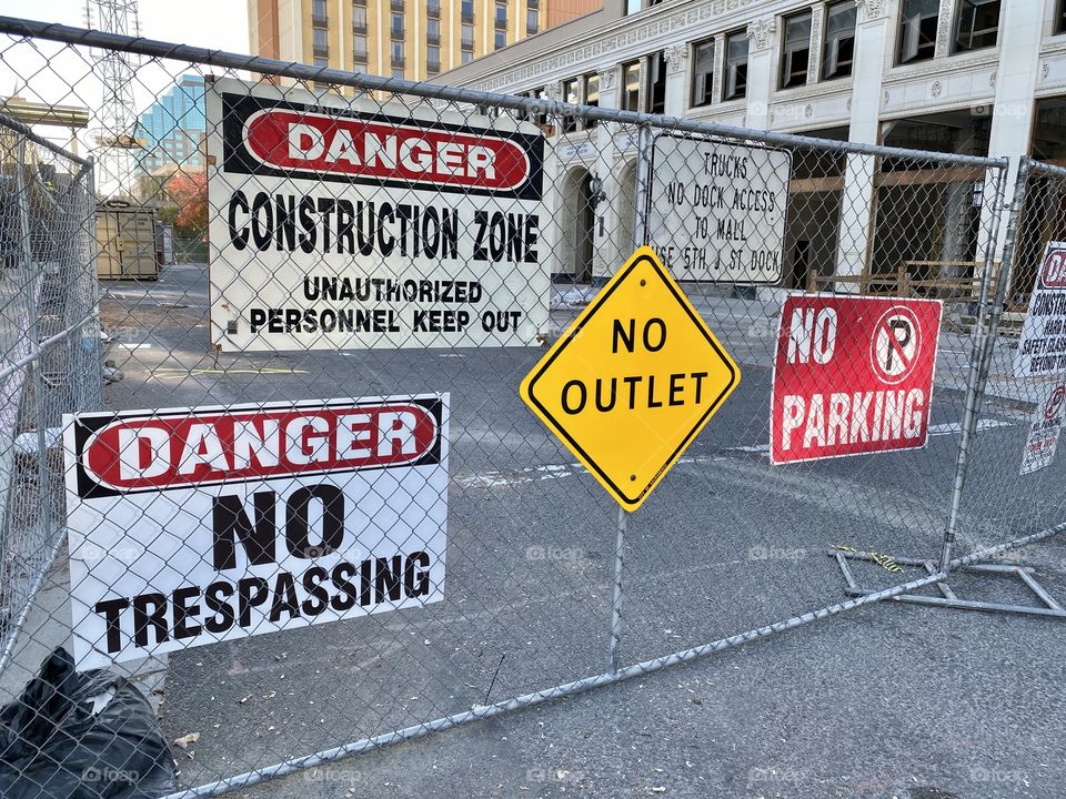 Danger and construction signs on fence 