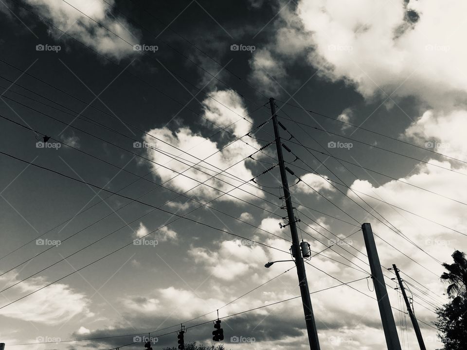 Power lines in a clouded black and white sky