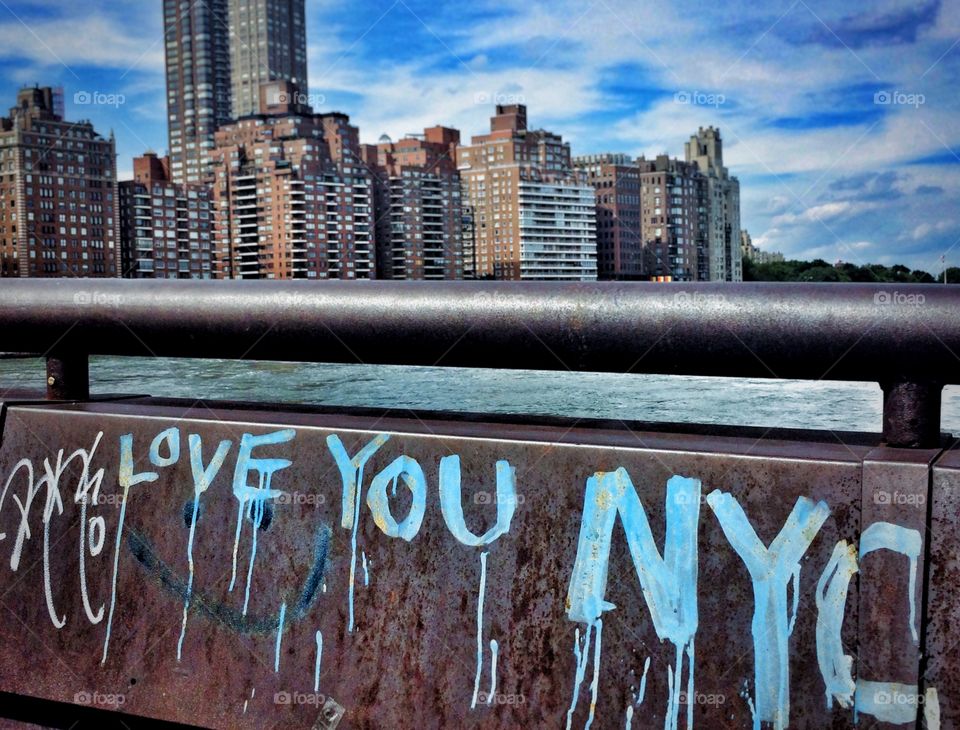 Love You Nyc. Graffiti in roosevelt island park with upper Eastside buildings in background 