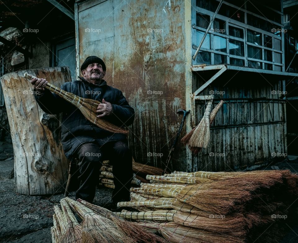 Senior man selling brooms