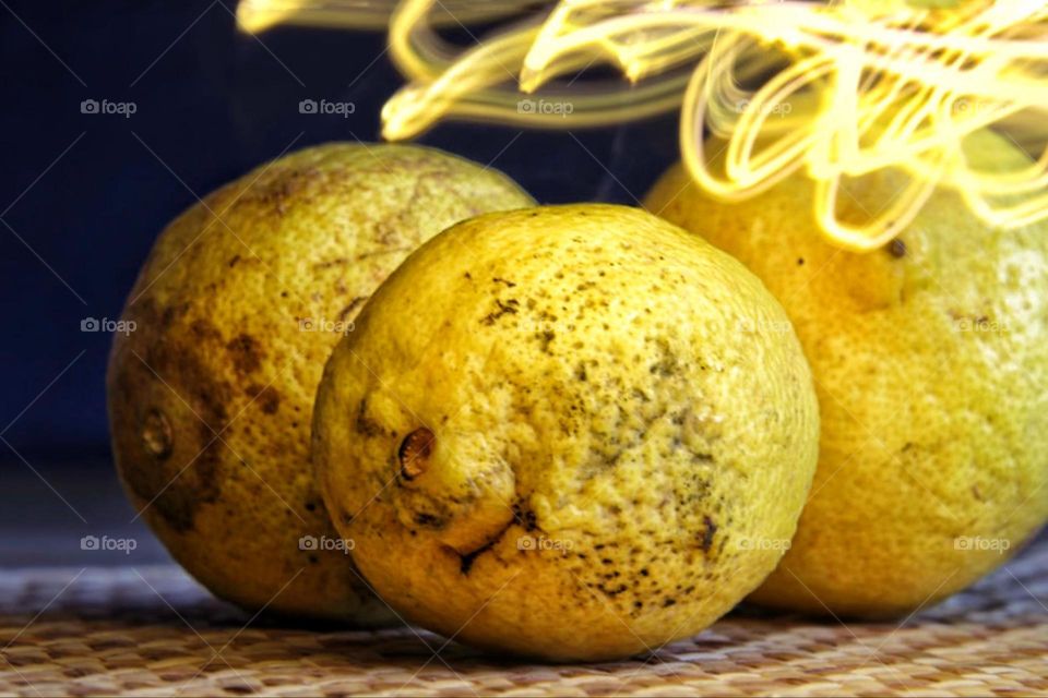 Light trail over three yellow organic lemons 