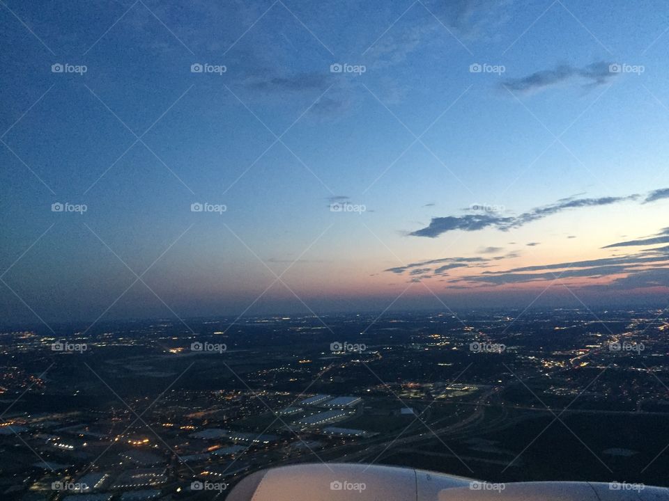 Airplane view of an evening sky and city below