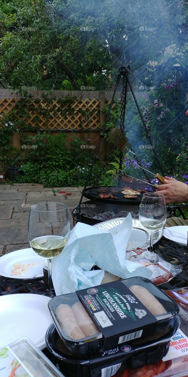 barbecue with table covered in food and wine glasses