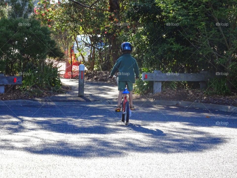 boy riding his bike up the road