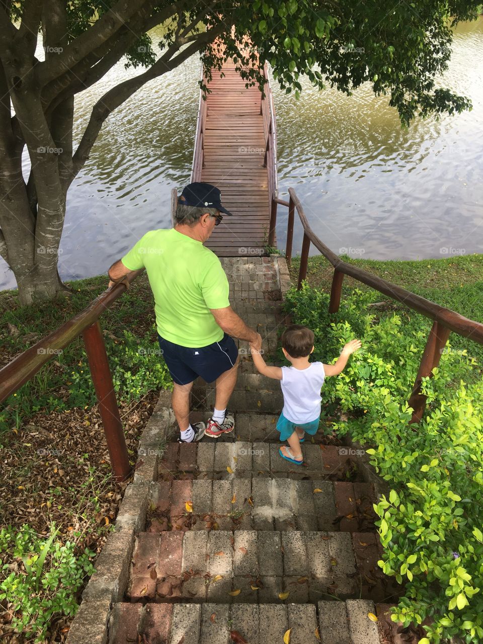 The joy of grandpa playing with his little grandson in the park. The lake will witness a lot of fun! Long live the family! / A alegria do vovô brincando com o netinho no parque. O lago será testemunha de muita diversão! Viva a família!