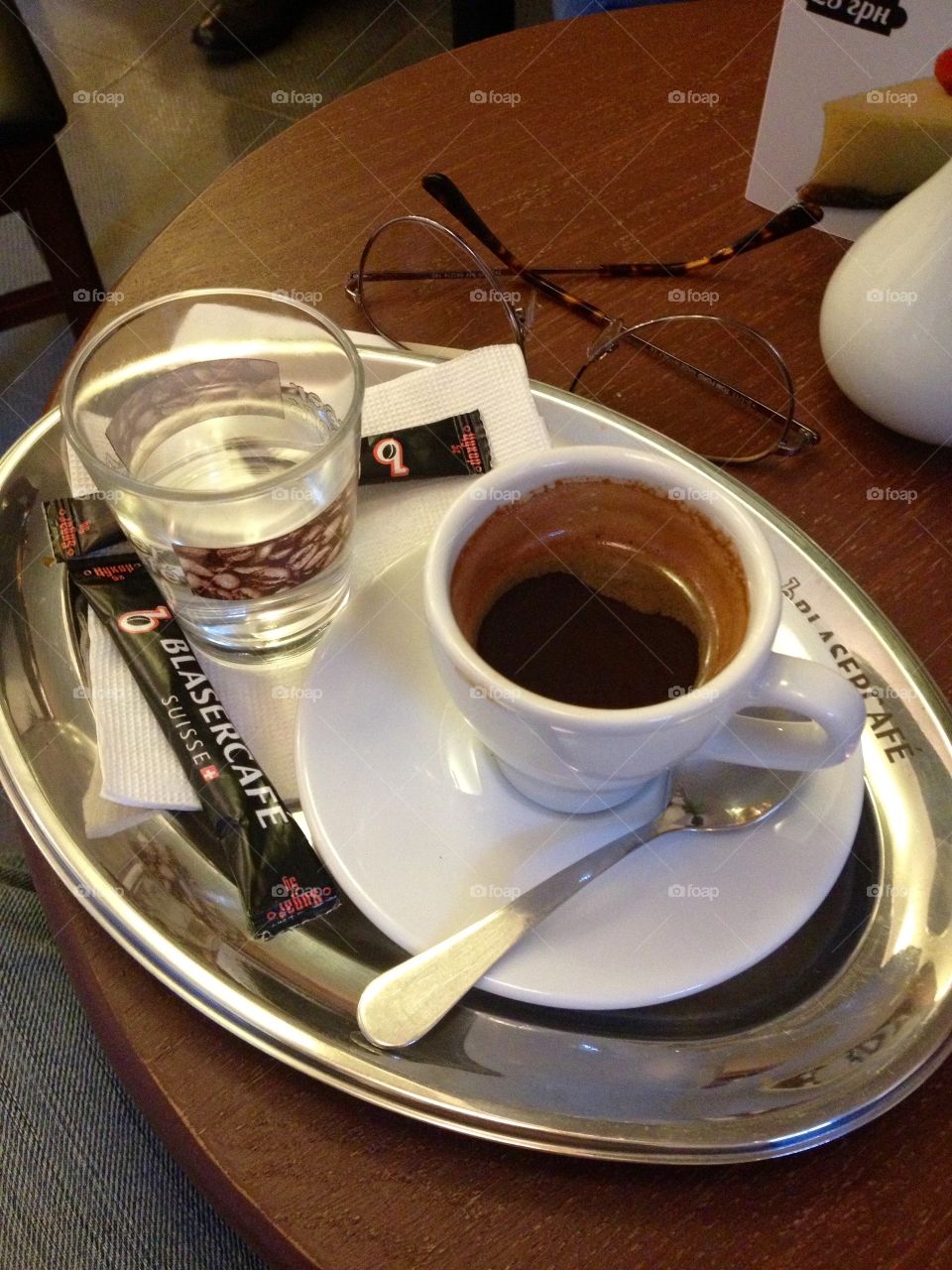 Traditional espresso with water in a glass on a steel tablet