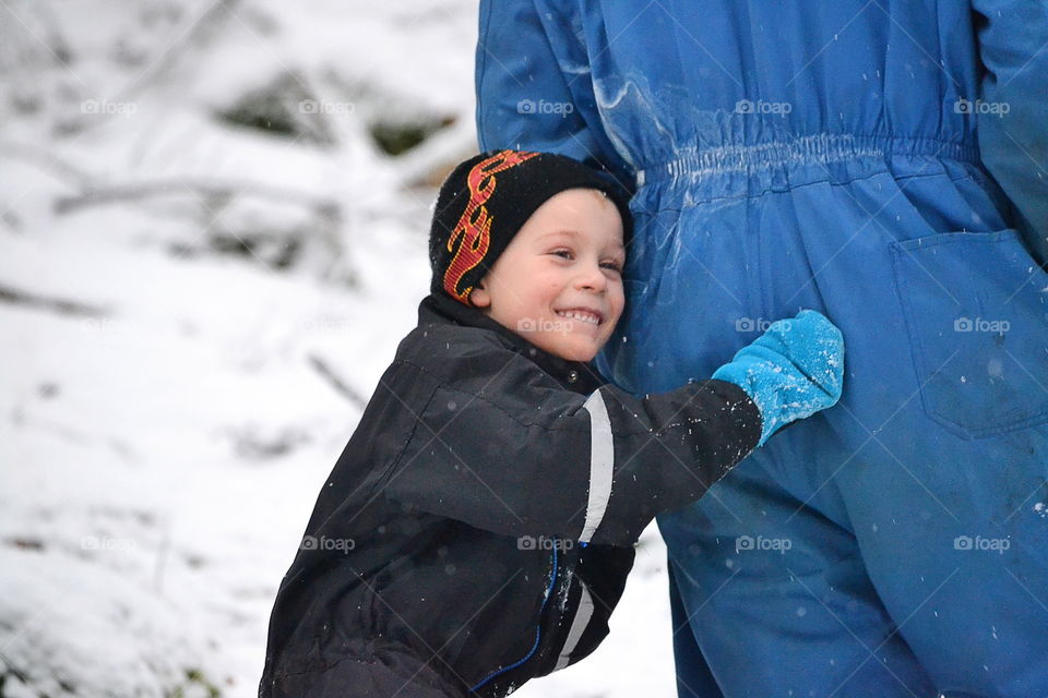 Boy hiding behind his father