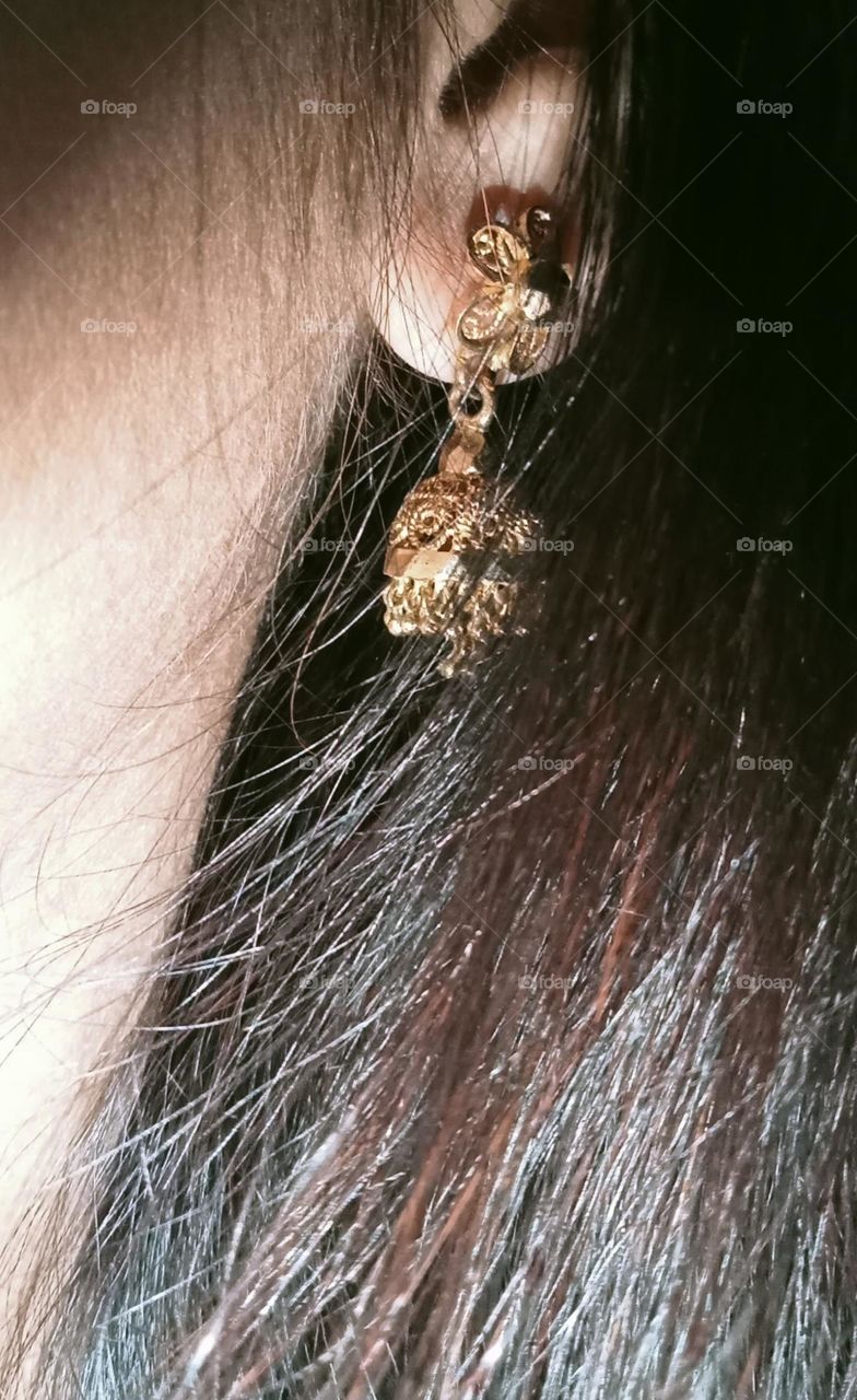 A very beautiful, silky hair and wearing gold plated beautiful earrings. This photo is earrings and also hairs photo.
