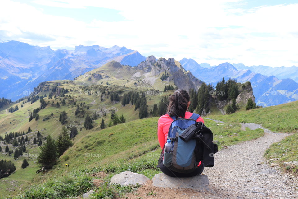 Hiker resting in front of mountain scenery. Go hiking.