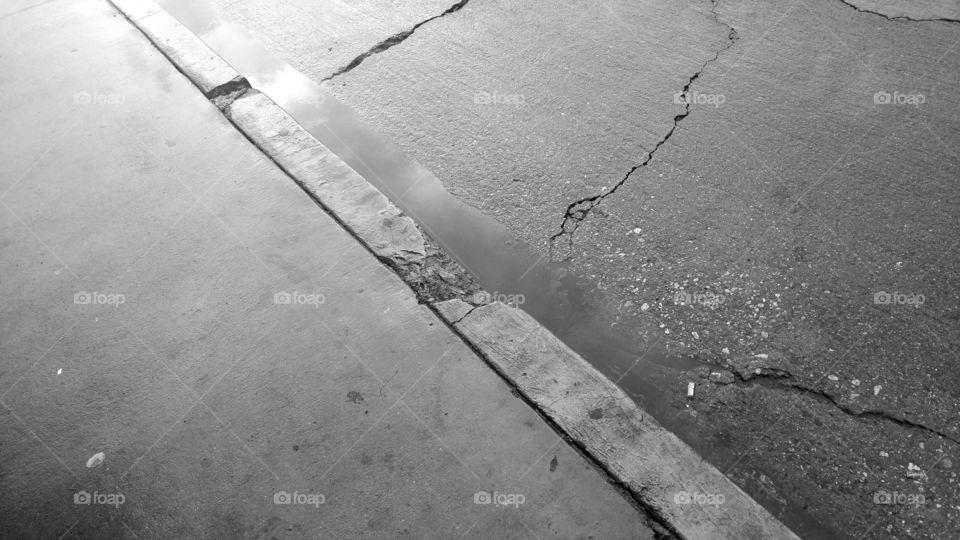 Puddles on a Sidewalk by the Road