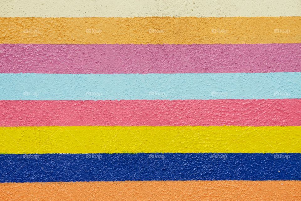 A multicolored stripe painted closeup of an wall.