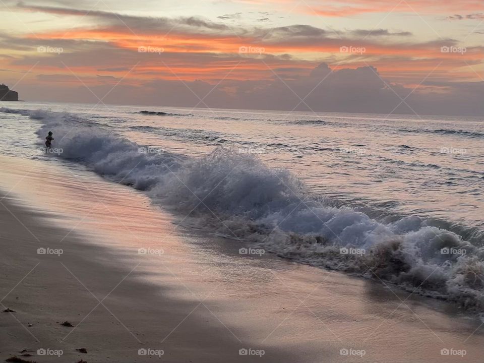 Waves crashing on the beach during sunset