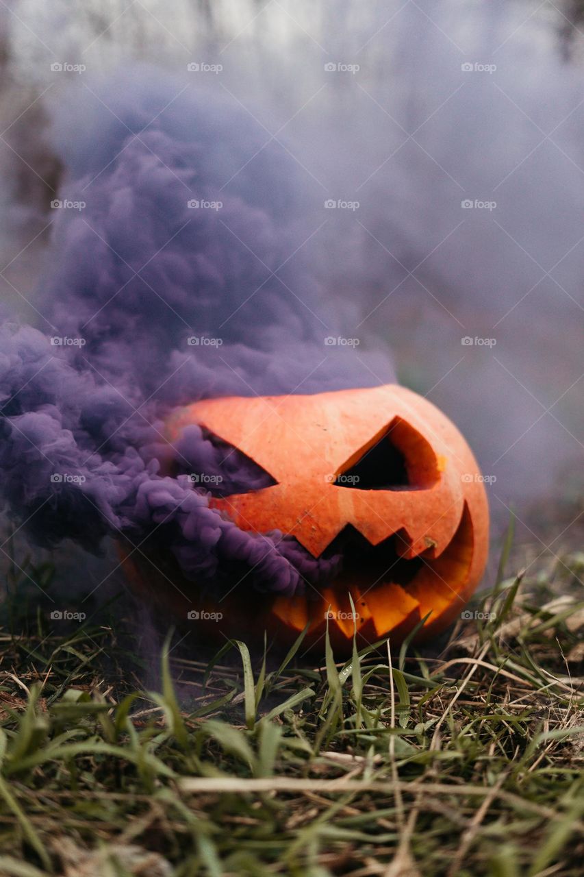 spooky season / carved pumpkin / purple smoke / jack o lantern 