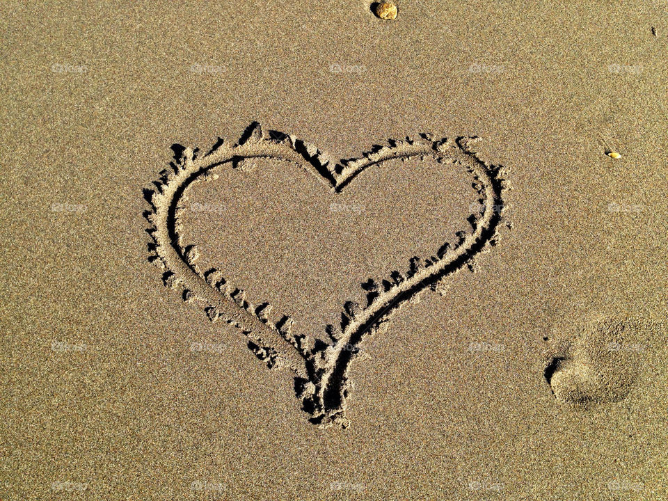 Heart drawn on sand at beach