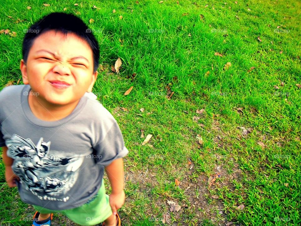 Little boy smiling and showing a funny face