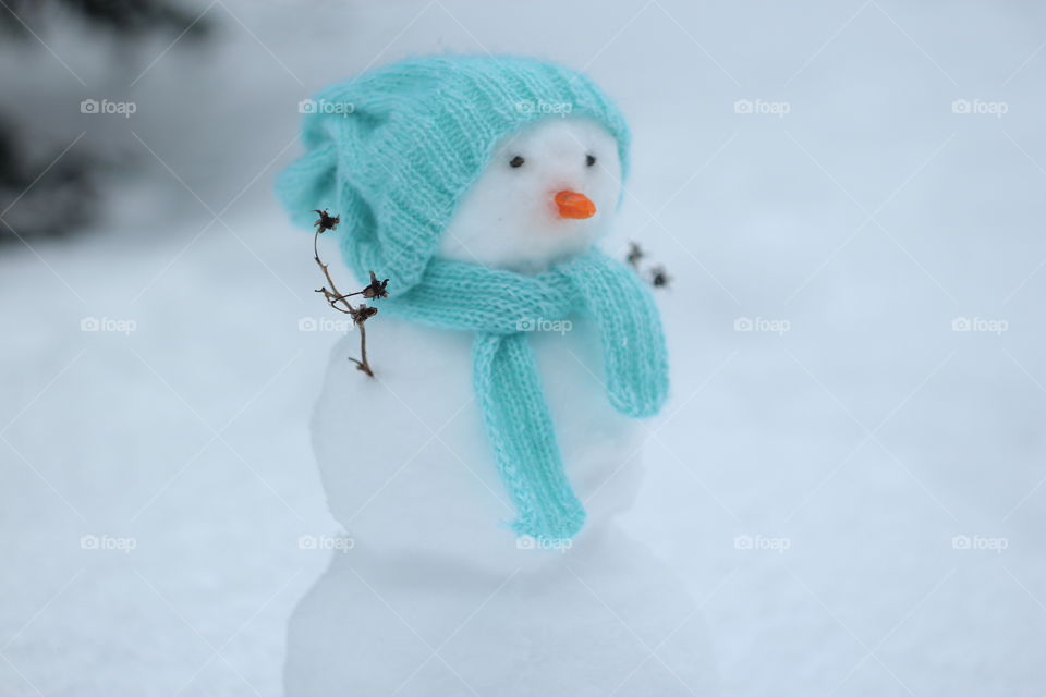 Snowman in a turquoise scarf and hat