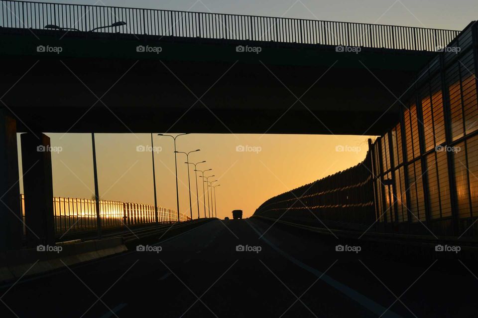 Golden hour during sunrise  on the expressway in Poland- driving under bridge