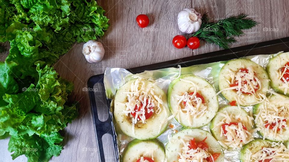 Zucchini under tomato and cheese in garlic before baking.