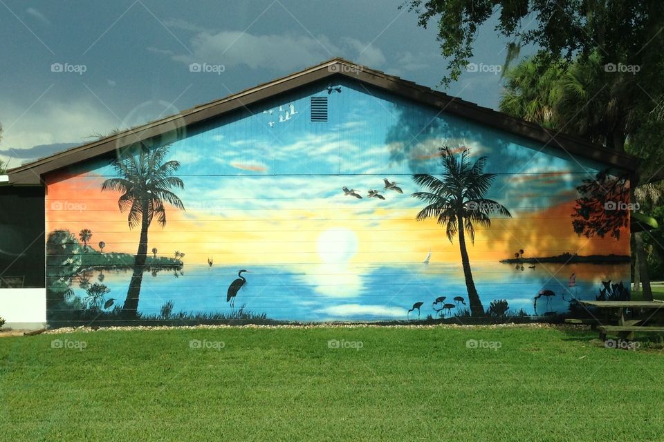 Tropical scene painted mural on the side of a building