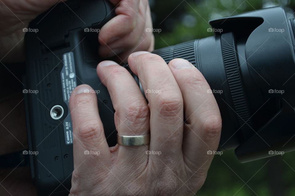 Closeup photographer focussing with zoom lens camera 