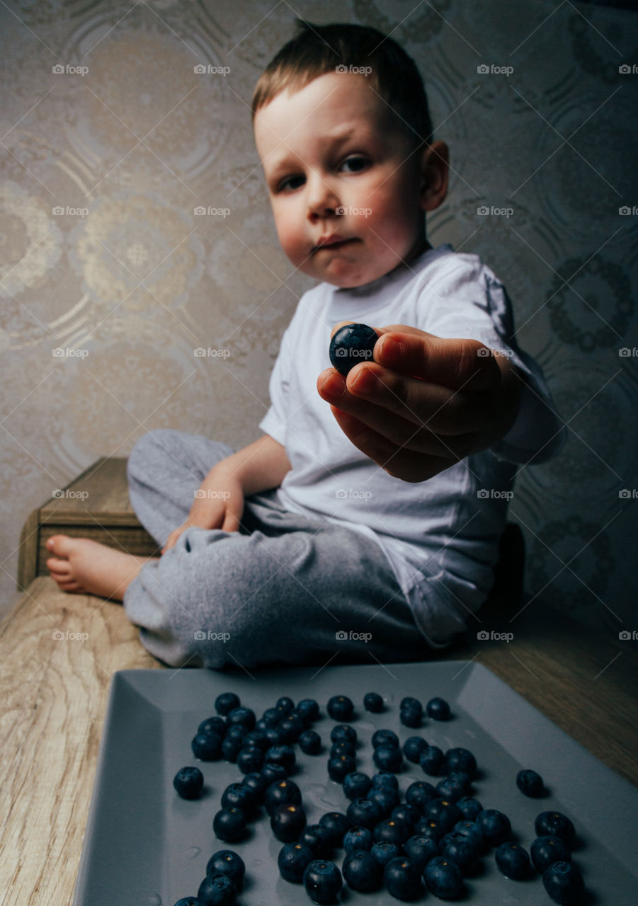 Boy holds the blueberries