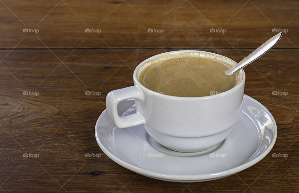 Hot coffee in white glass on wooden table