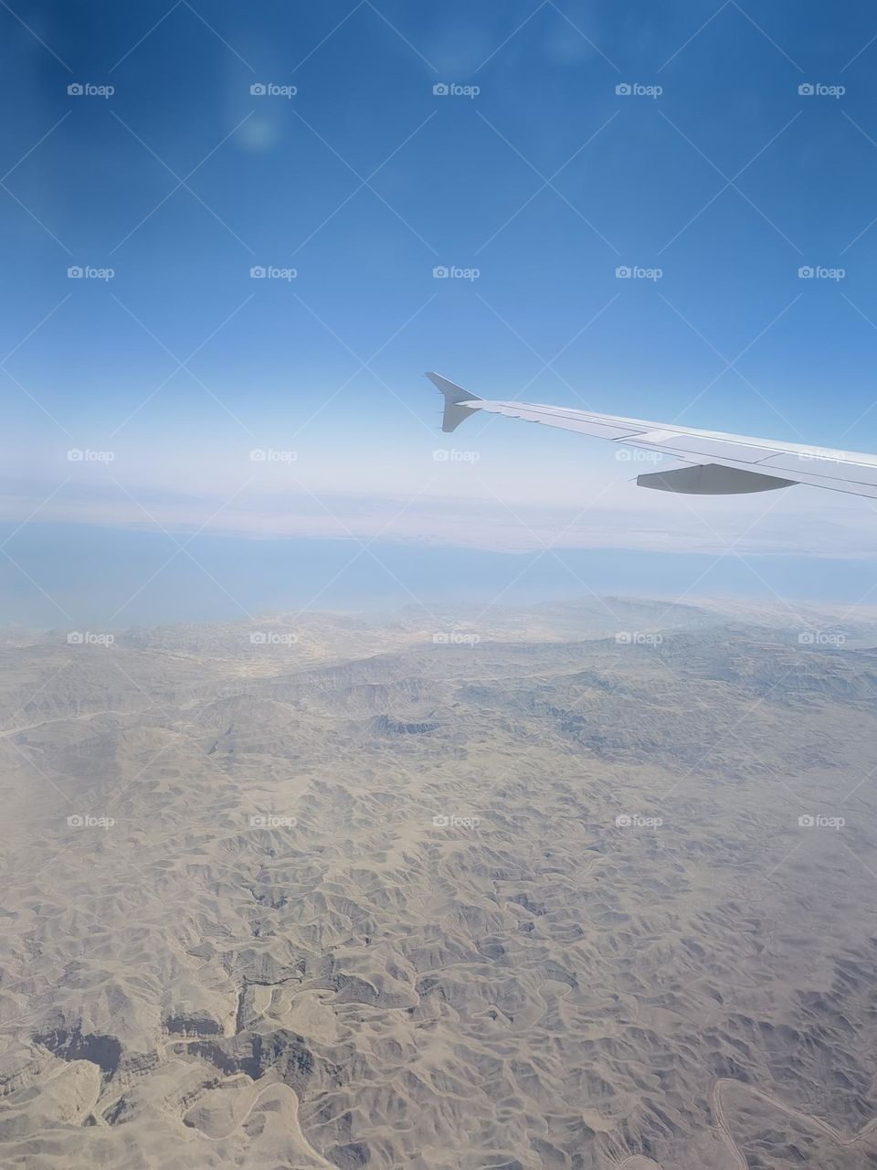 Sea and mountains from the window of the plane