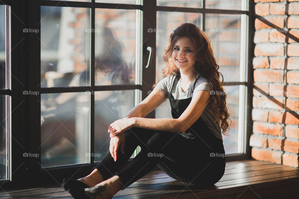 Portrait of young beautiful woman near window