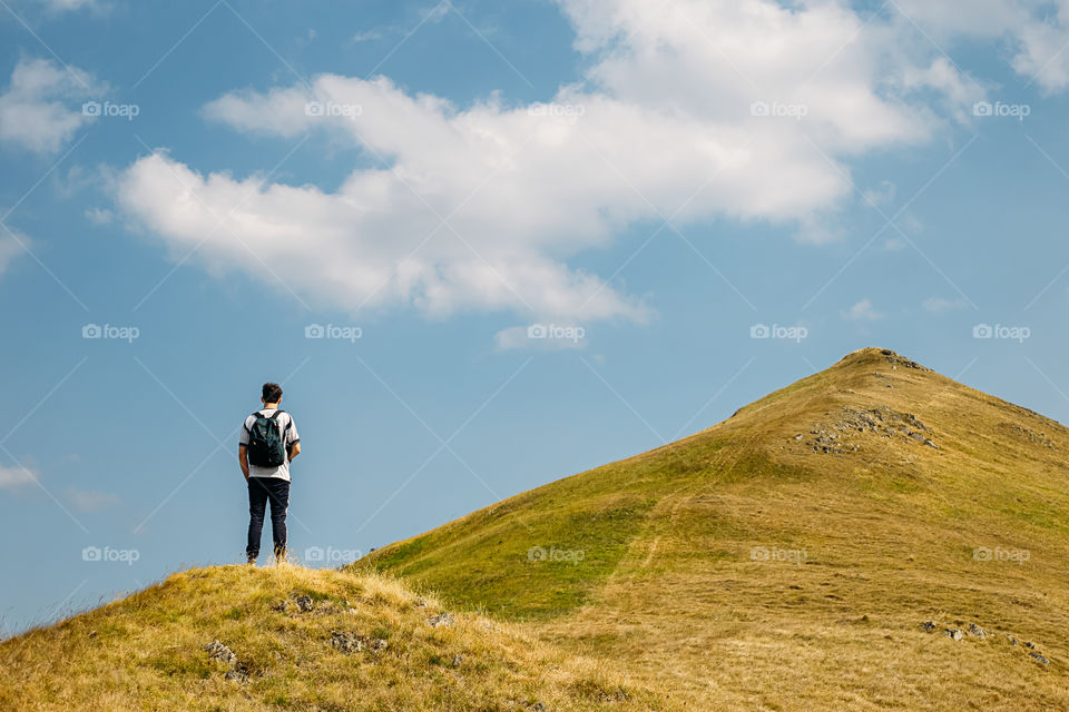 Rear view of man on mountain against sky .