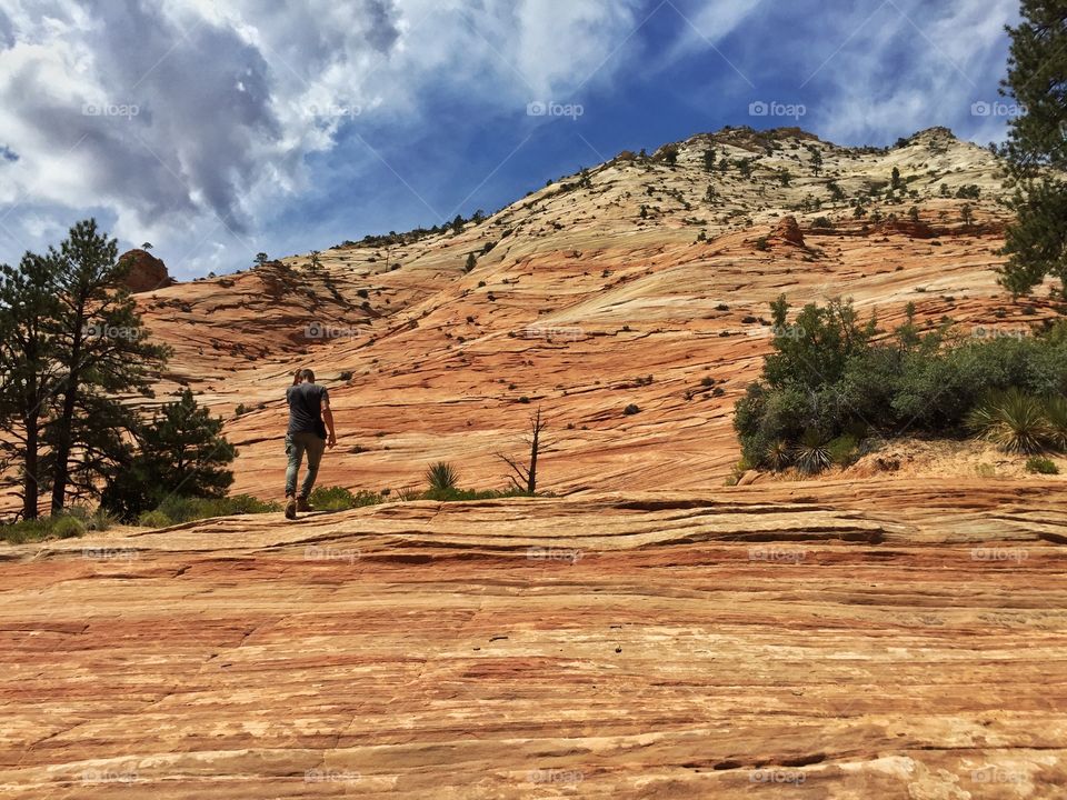 A man climbs a mountain of the Zion park national park,Utah