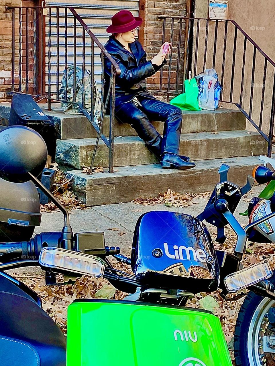 Passionate LIME electro scooter rider Petra Schiller is taking a rest sitting on a stoop in Fort Greene, Brooklyn, New York off Fulton Street on a still unseasonably warm early afternoon in December 2021. Hypnotic Productions