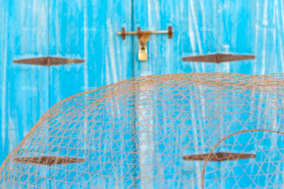 Traditional fisherman net against blue painted door