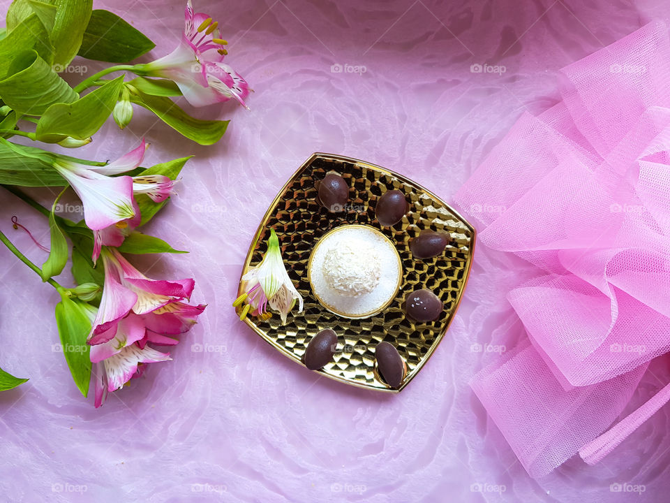 different types of chocolate on a sugar covered golden plate decorated with flowers, the white one is my personal favourite covered with coconut pieces