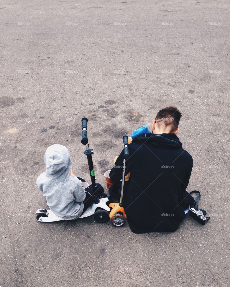 Father and son relaxing on the street
