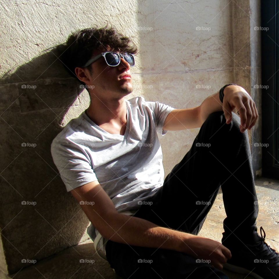 Boy sitting on the window porch with the sun on his face