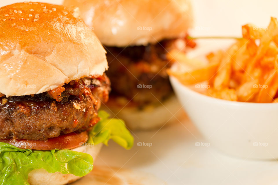 Enjoying delicious mini burger and fries - closeup of food