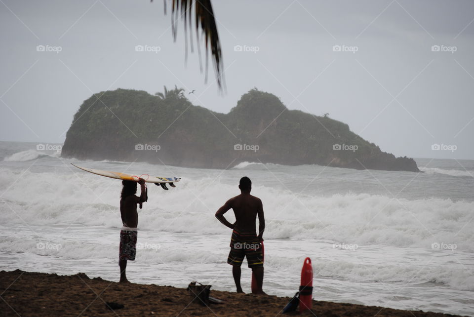 Silhouette of two men standing on beach