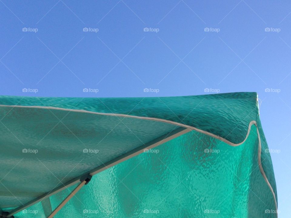 Green parasol against the blue sky
