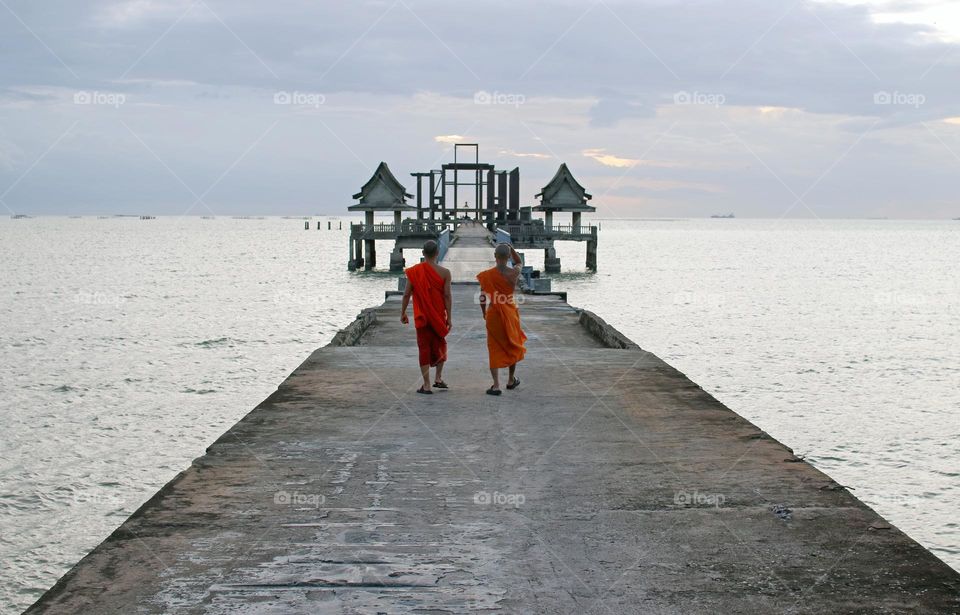 Thai Monks at a Pier of an abandoned Buddhist temple in Thailand Southeast Asia during the evening