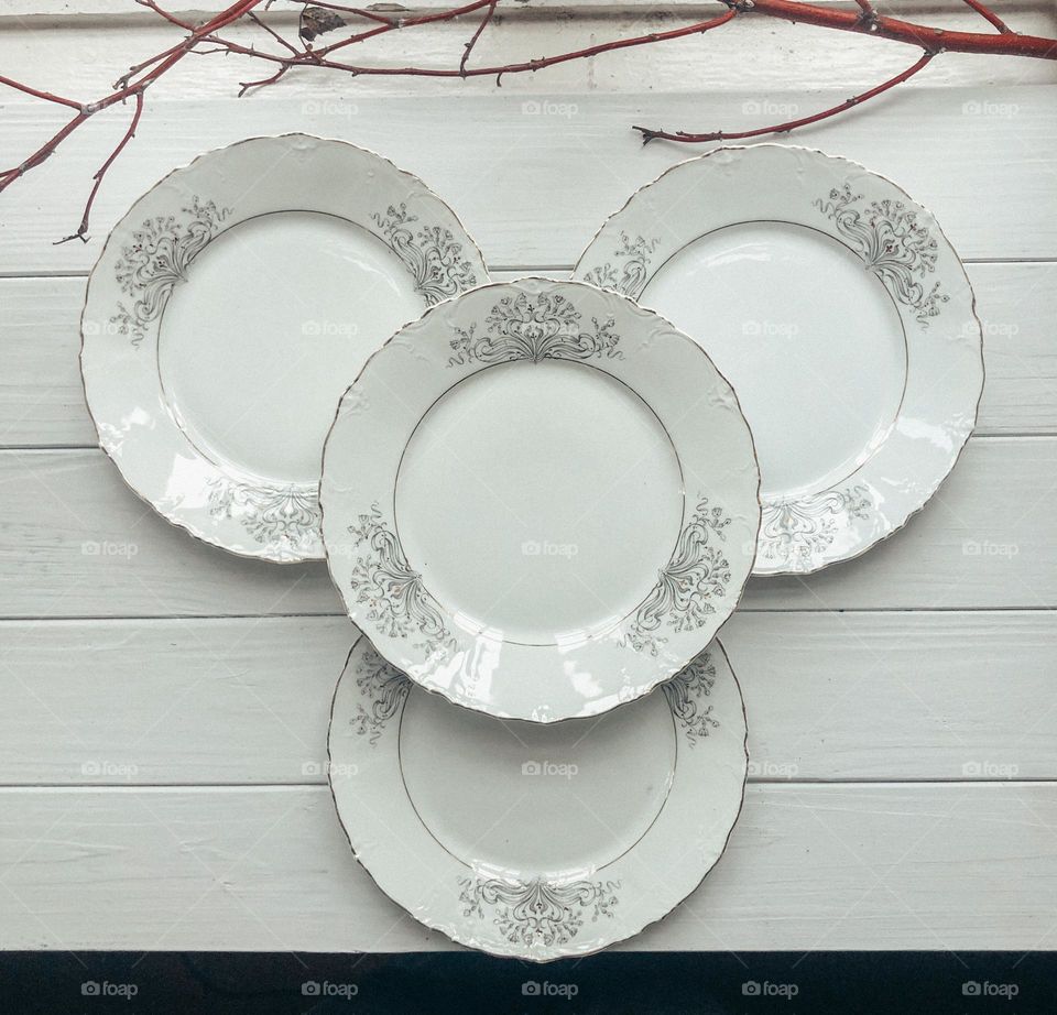 Old white porcelain plates with ornaments 