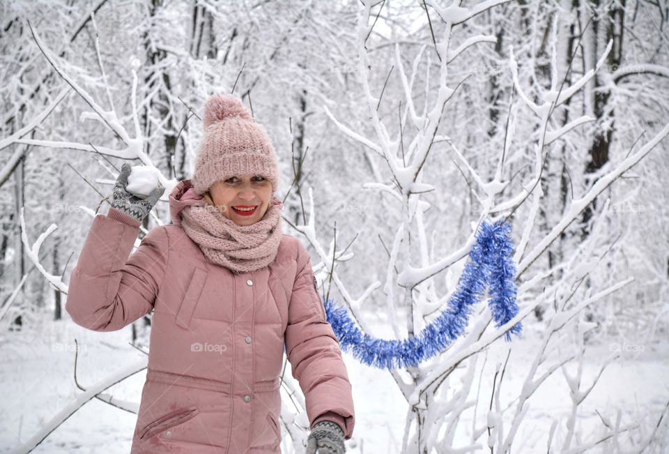 woman smiling and playing in snow in the winter park Christmas time