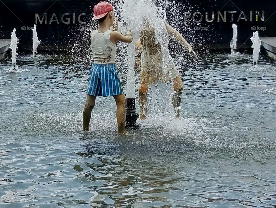 Sculpture of children playing in a water fountain.