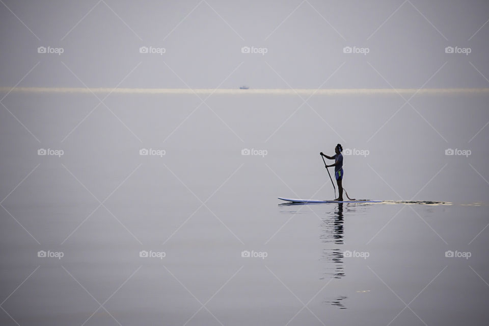 Tourists on surf boards in the sea at Prachuap Bay in Thailand.