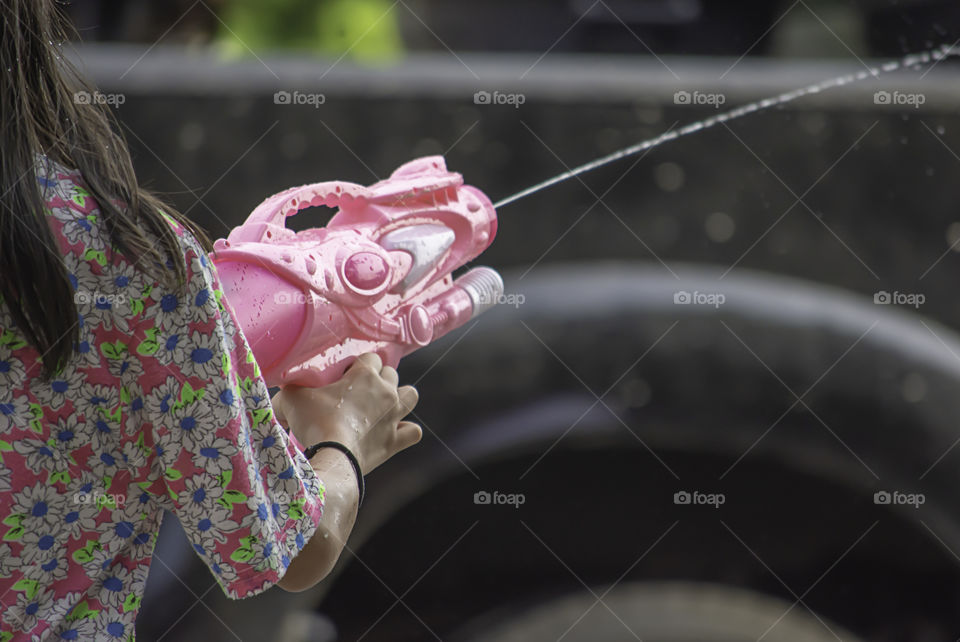 Hand holding a water gun play Songkran festival or Thai new year in Thailand.