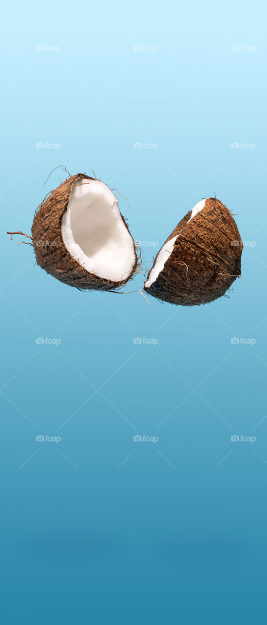 Cracked coconut falling. Phone wallpaper. 21:9